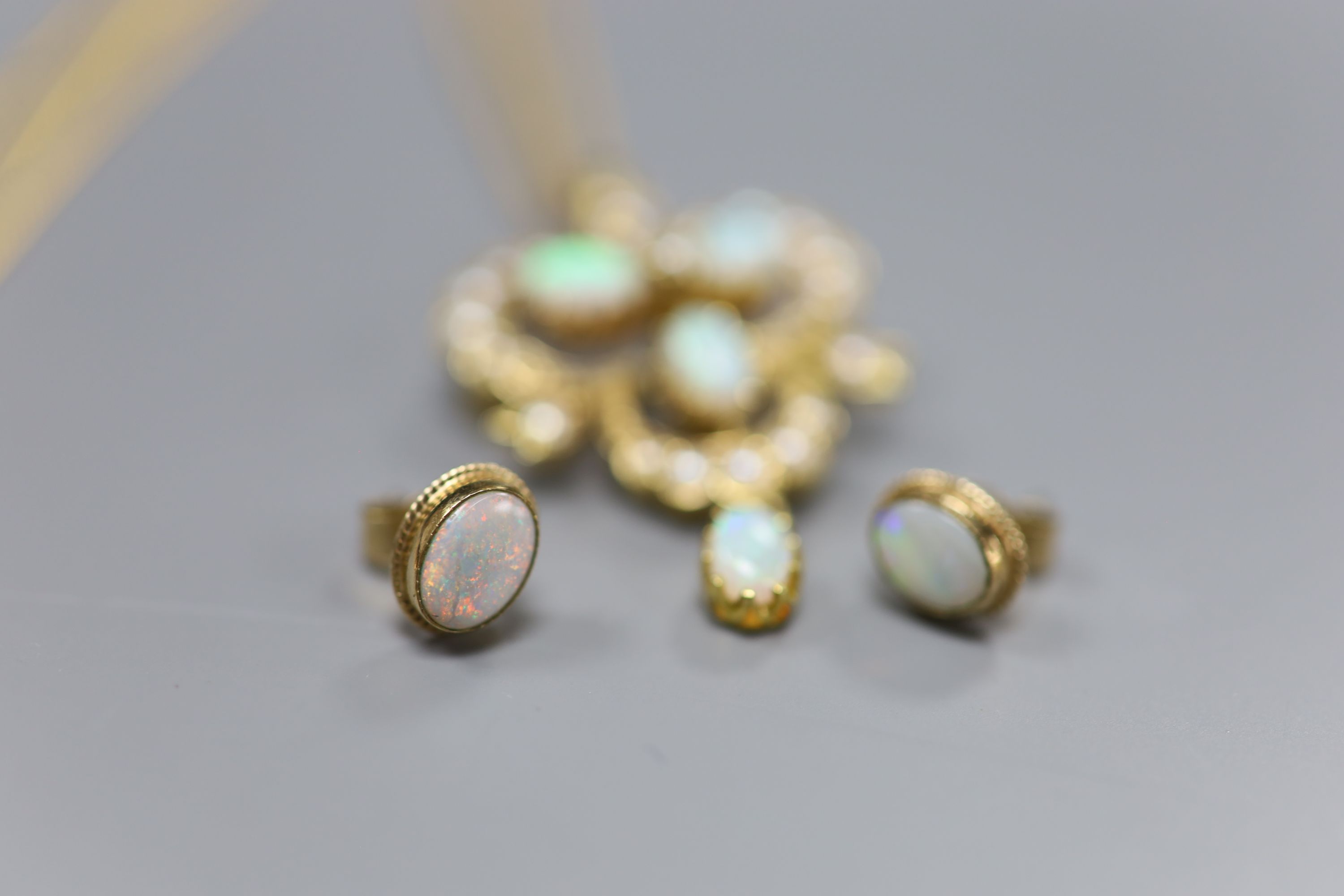 A modern 9ct gold, opal and seed pearl openwork drop pendant, on 9ct gold chain and a pair of opal 9ct stud earrings, gross 9.1g.